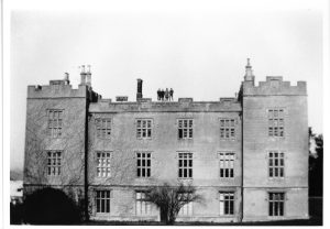 1934 - The end is nigh for the old Compton mansion house. After ten years of neglect, its condition had deteriorated to such an extent that it was deemed unfeasible to restore. Workmen stand on the roof ready to commence its demolition.