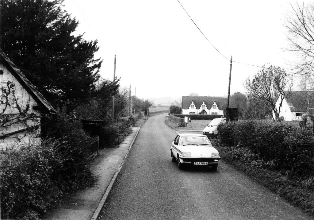 48 CB ahead and Benson Village Hall at right. 1990